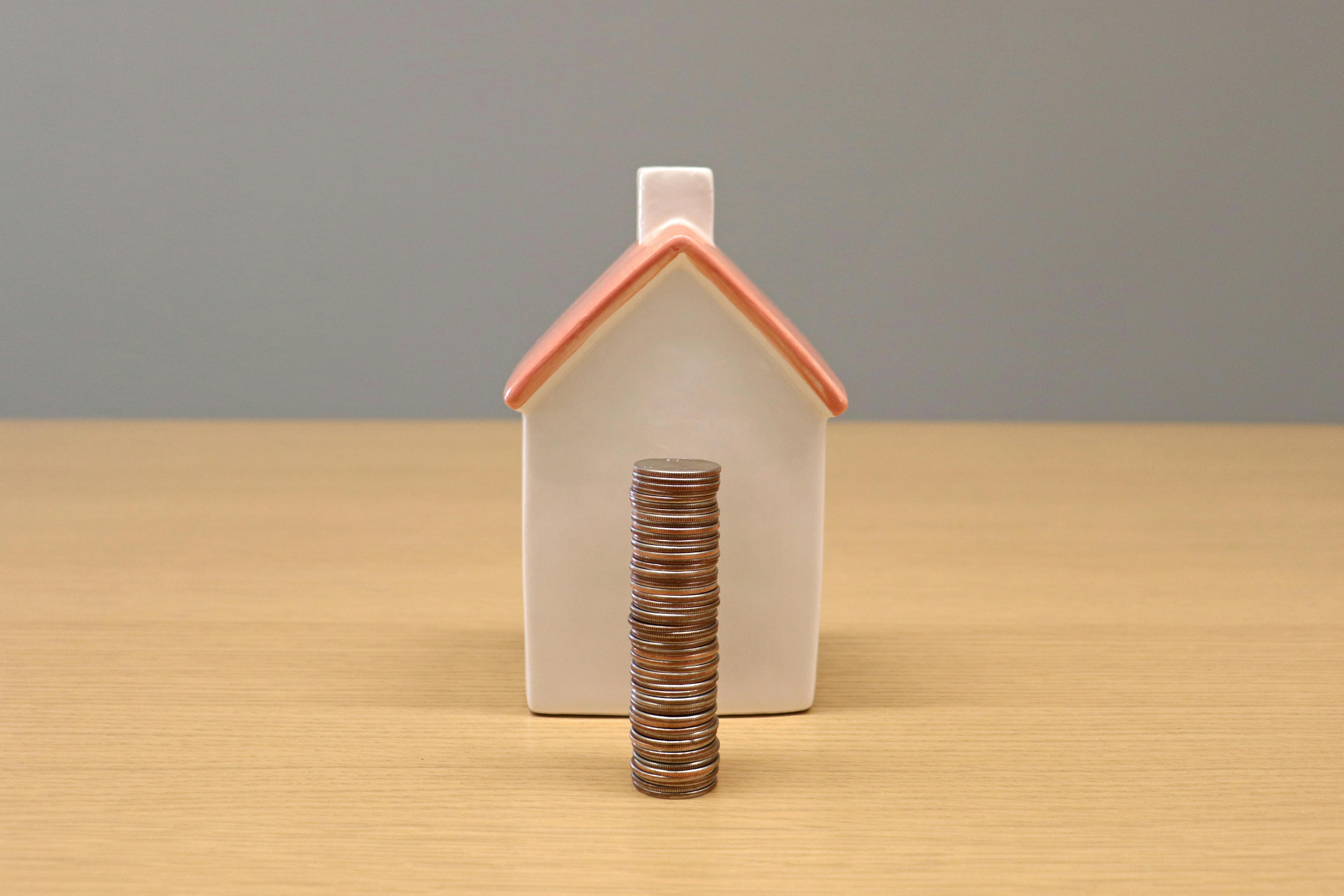 Model Home behind a Stack of Coins